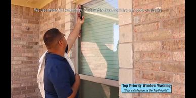 A man cleaning a window using water technology for spotless results.