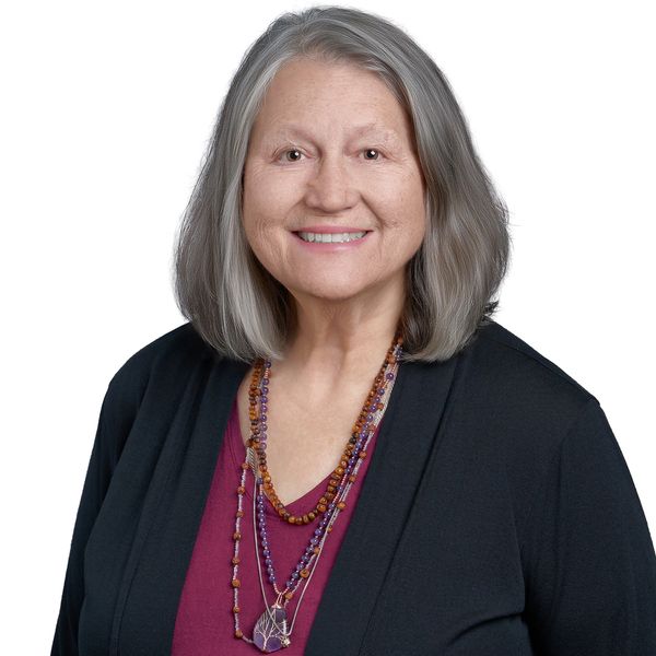Professional headshot of Carolyn smiling in her black suit jacket.