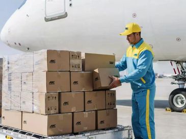 Worker loading packages onto an airplane at the airport.