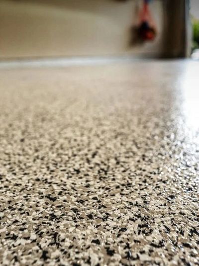 Close up of concrete floor with black and tan flake finish