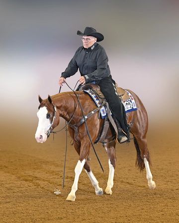 Man riding a horse in an indoor arena.