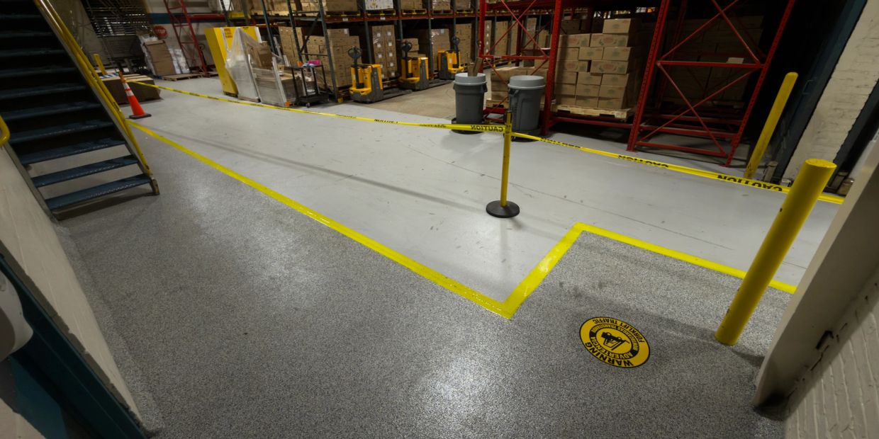 Industrial warehouse area with caution tape and warning sign.