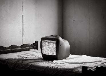 TV antigo com estática em uma cama.