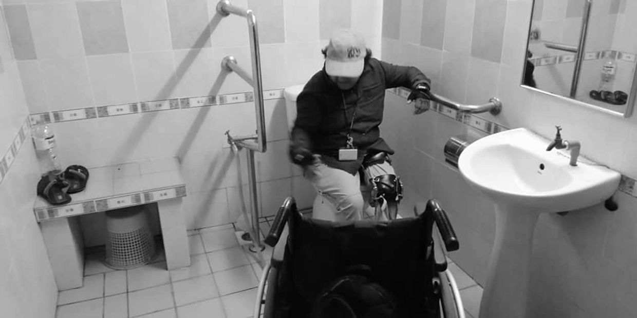 Access auditing an accessible room at a university's residence, checking the design of the bathroom.