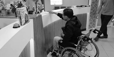 A trainee doing simulation exercise using a wheelchair to evaluate the counter design.