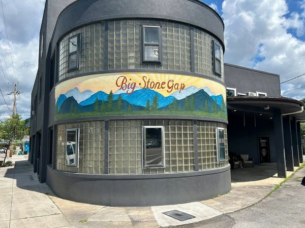 Curved building with glass blocks and a mural reading 'Big Stone Gap'.