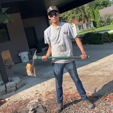 Javier Rodríguez with a pickaxe at Martinez Landscaping 