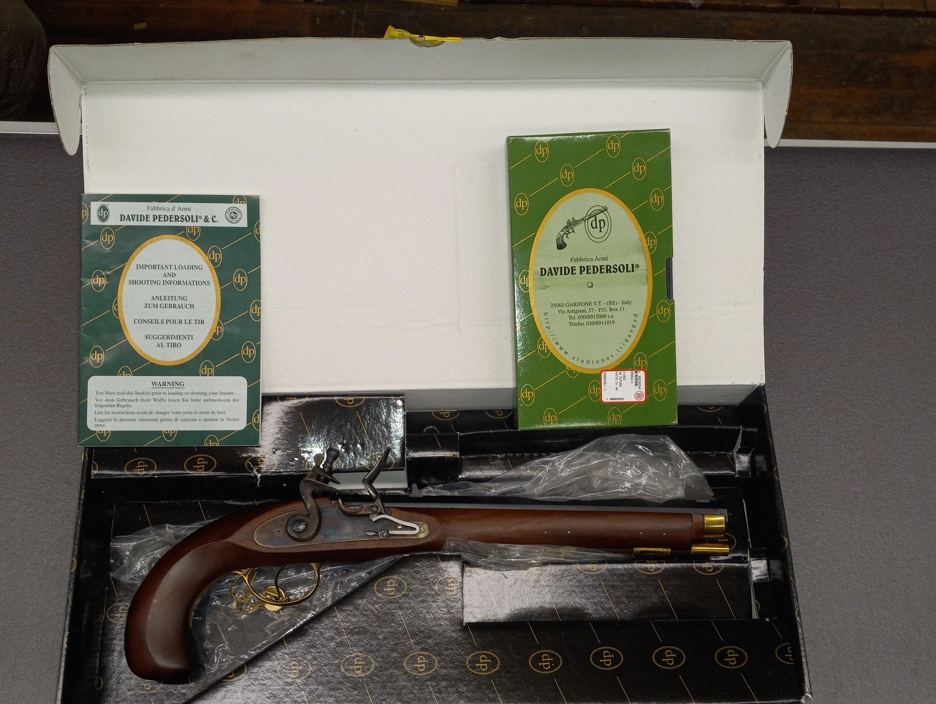 A vintage Davide Pedersoli flintlock rifle in its original box with manuals.