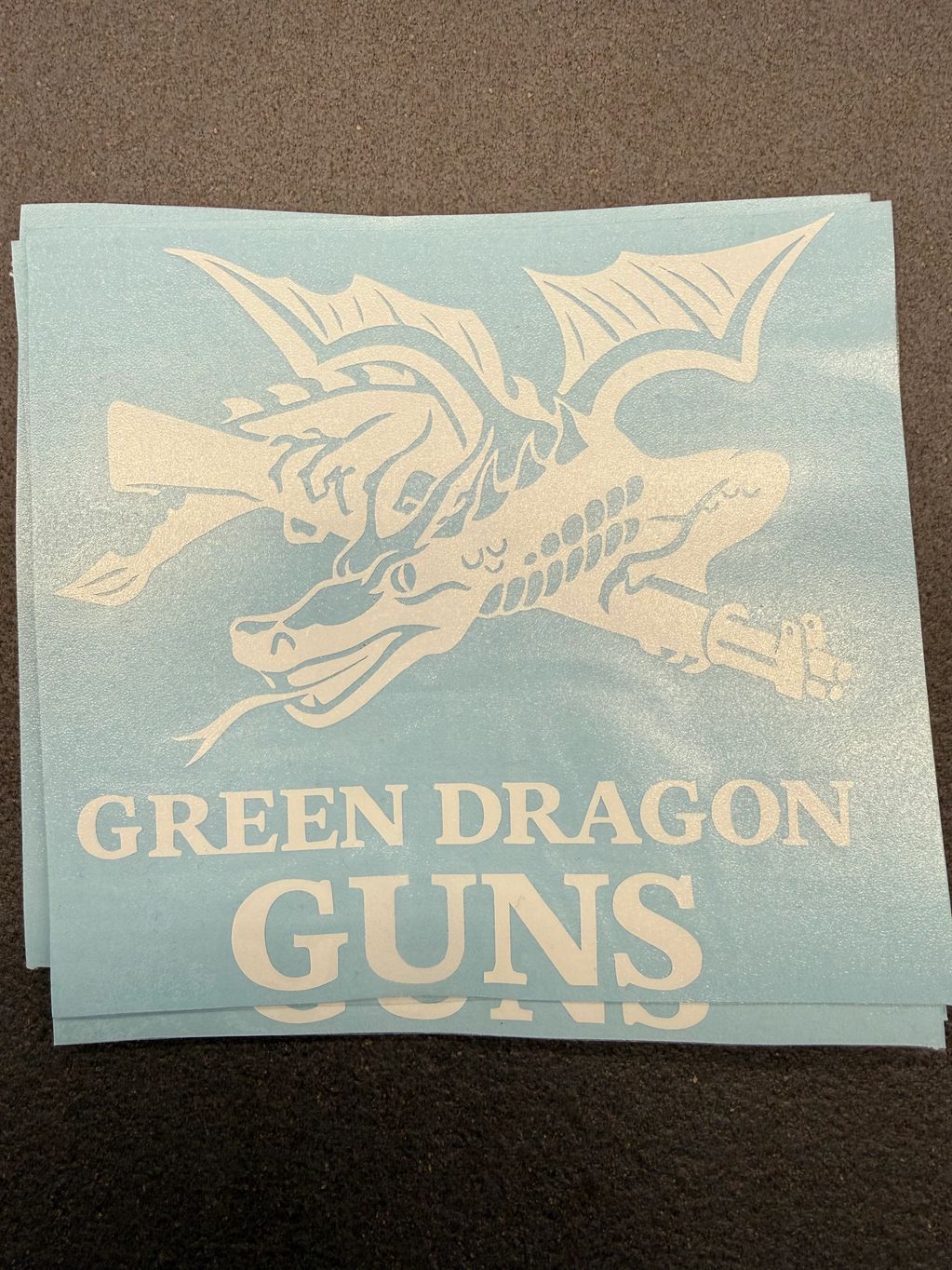 Logo with a dragon holding guns and text 'GREEN DRAGON GUNS'.