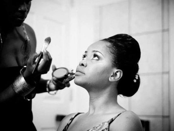  bride getting her make up done by her Make up artist on wedding day