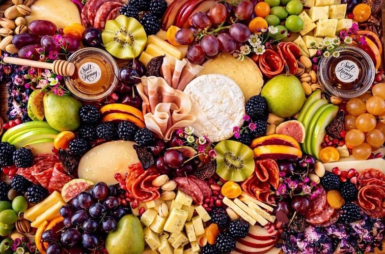 Stack of books next to pencils in a holder and a camera.
