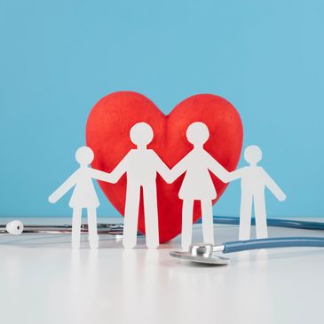 Paper cut out family with stethoscope and big red heart