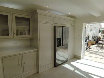 Modern kitchen with built-in cabinets and stainless steel refrigerator.