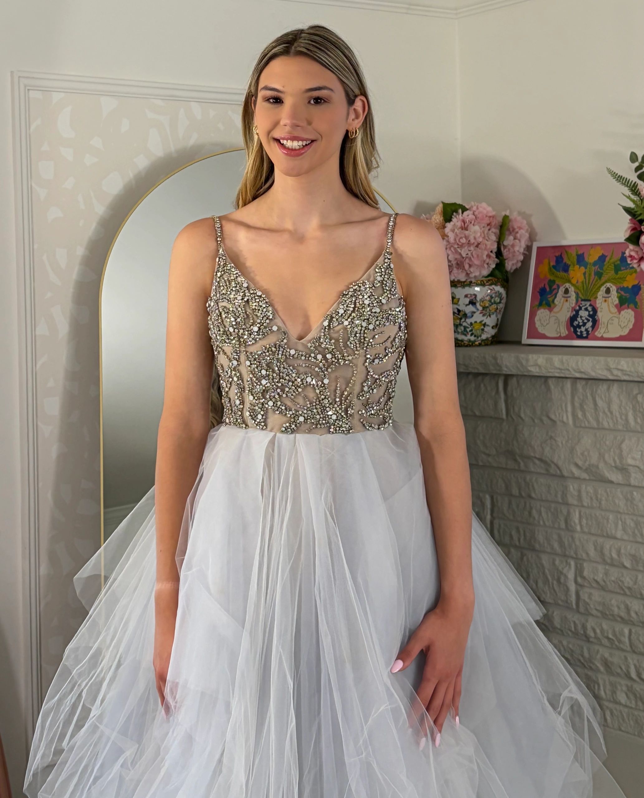 Young woman in an elegant beaded gown with tulle skirt.