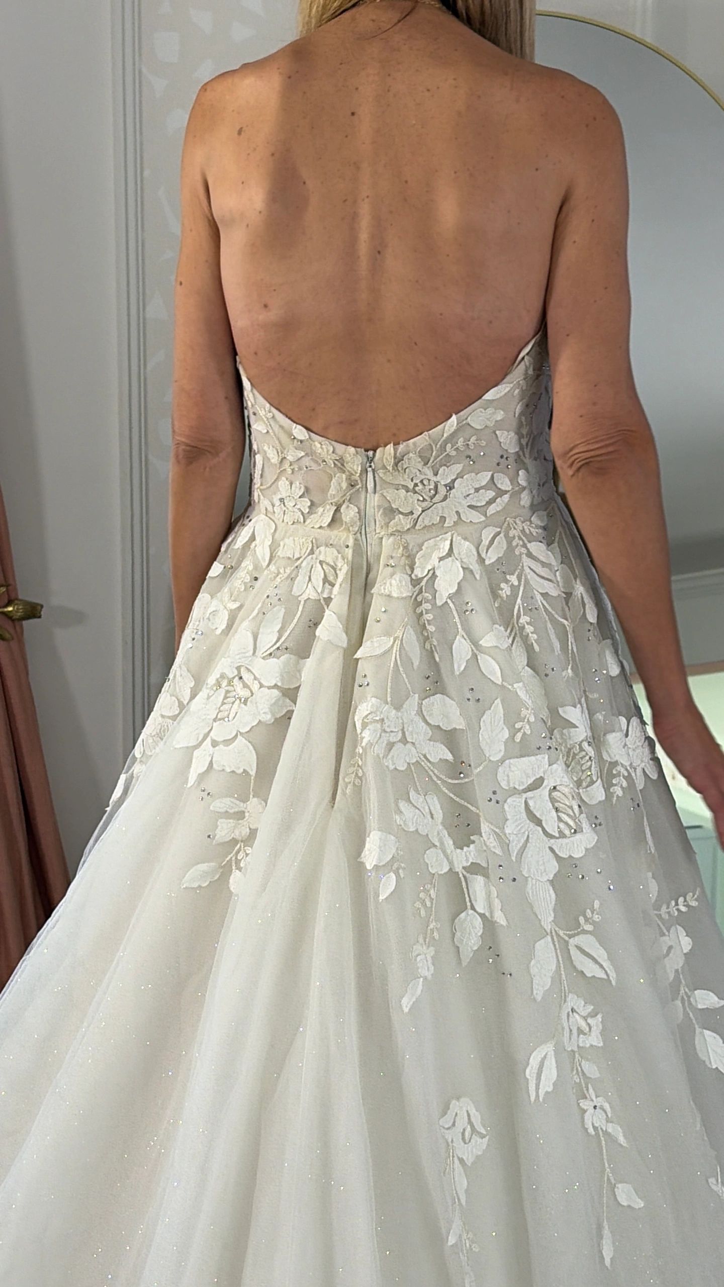 Back view of a woman in a white floral wedding dress.