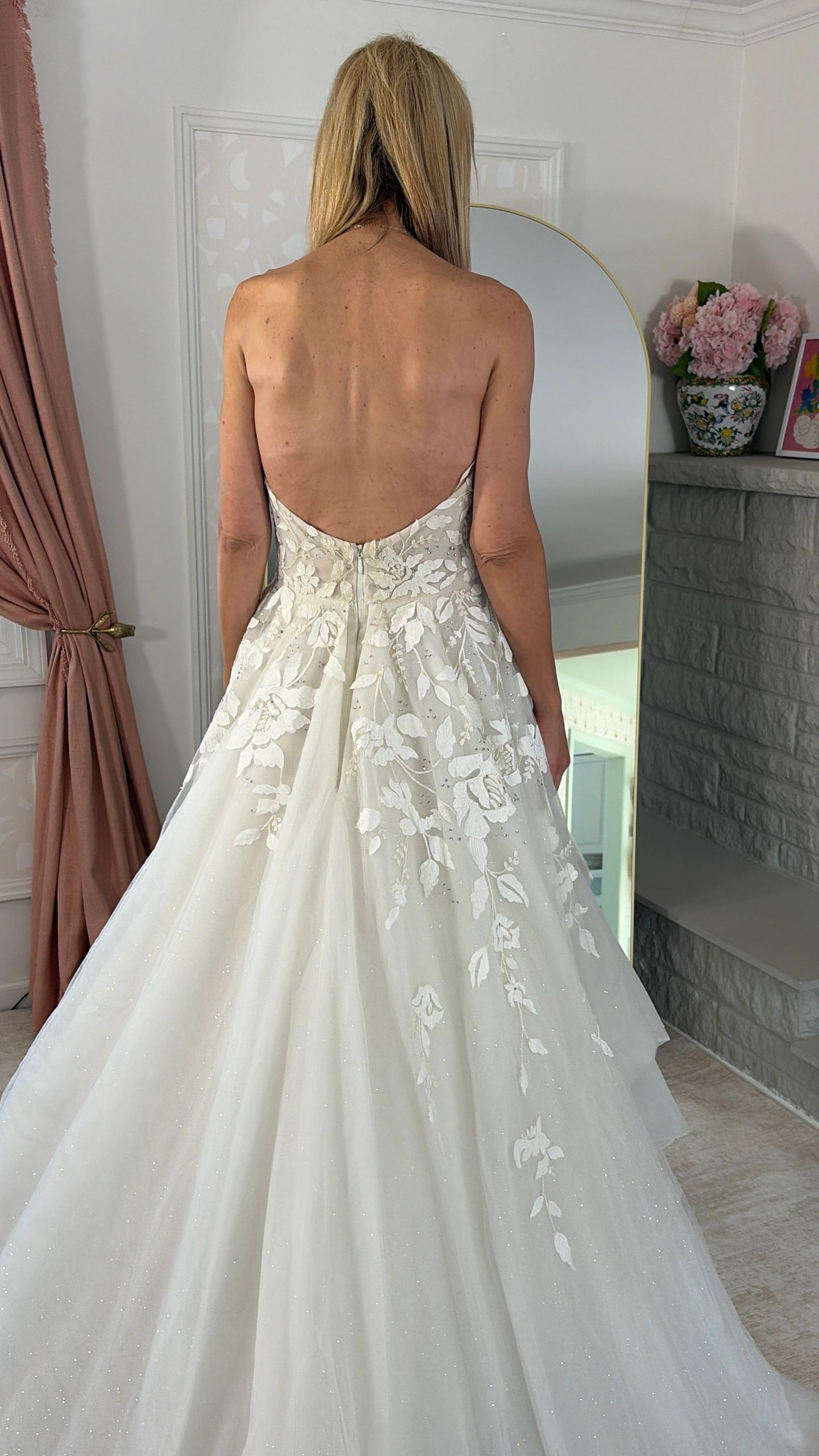 Woman in a backless wedding dress with floral details.