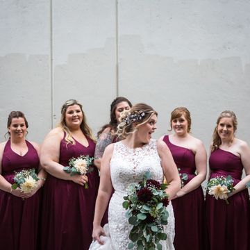 The bride holding her cascading bridal bouquet and her girls are behind her. London Ontario florist