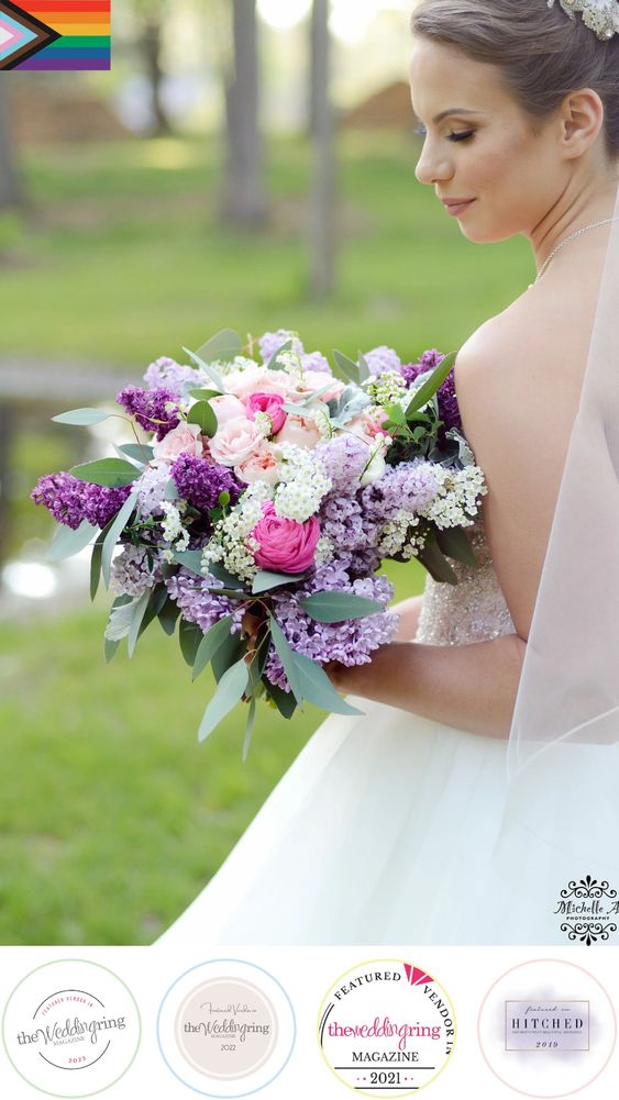 Bride standing with her back towards us, looking down at her spring flower bouquet.