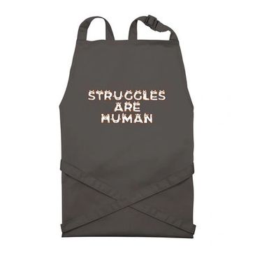 Dark apron with 'Struggles Are Human' text.