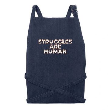 Dark blue apron with 'Struggles Are Human' text.