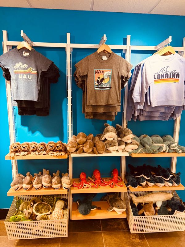 Shelves of Maui and Lahaina themed shirts and ocean animal plush toys.