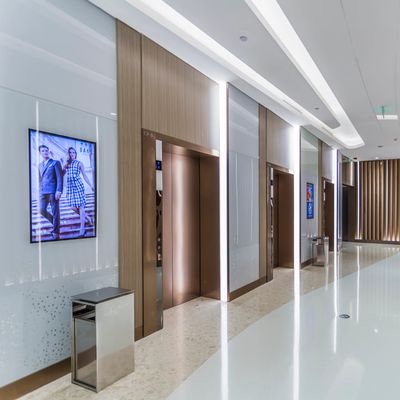 Modern elevator lobby with polished floors and digital displays.