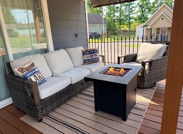 Cozy outdoor seating area with a fire pit table on a porch.
