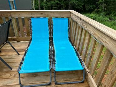 Lounge on the sun deck at Cottage Too surrounded by peaceful woods.