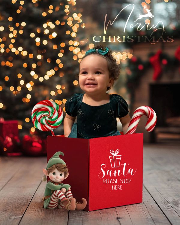 Smiling toddler in a Christmas box with festive decorations and text.