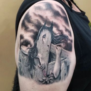 Black and gray tattoo of a girl with horns peeking from behind wooden planks.