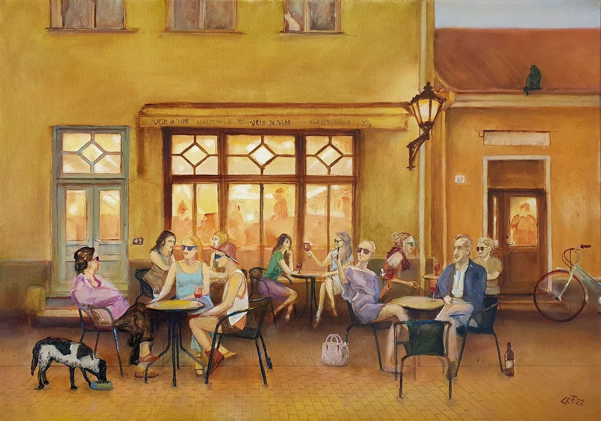 People socializing at an outdoor café in warm lighting.