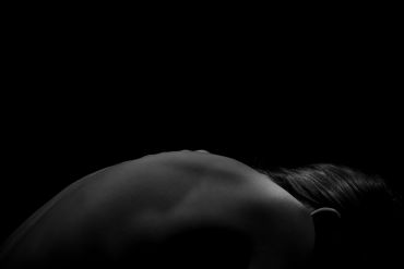 Artistic black and white photo of a person's back and shoulder.