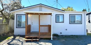 Small white house with a wooden porch.