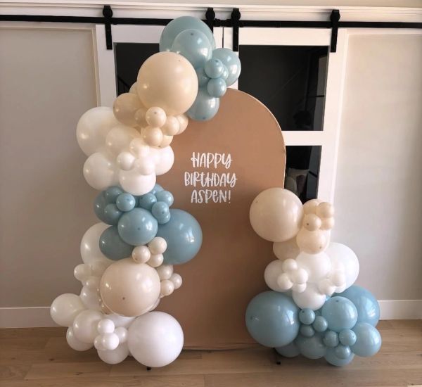 Blue, white, and beige balloon arch with a birthday message for Aspen.