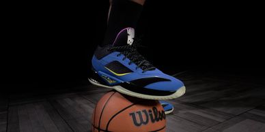 Basketball shoe stepping on a basketball.