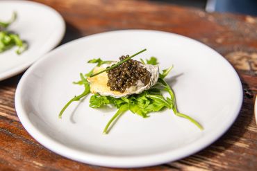 Gourmet oyster with caviar and greens.