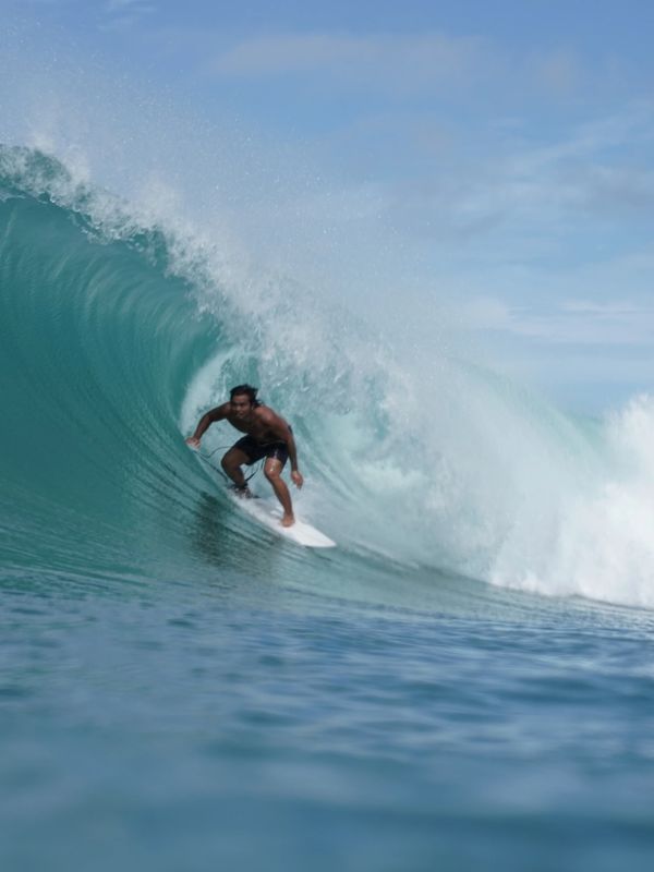 Alex Wau, head coach and founder of Spicy Surf School getting barreled at his home break in Nias (No