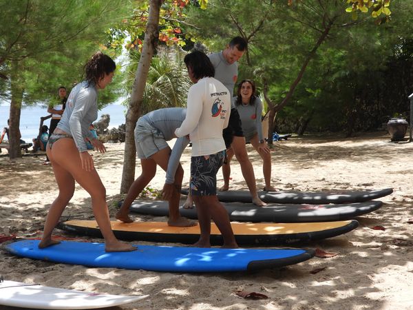 Group of people taking a surf class with Spicy Surf School in Bali, Dreamland Beach.