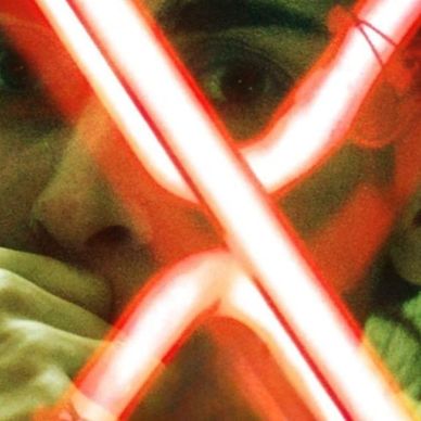 Person's face partially obscured by glowing red neon lights.