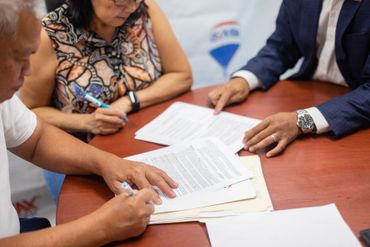 Clients signing a contract at our former real estate company owned by Houses We List for home search