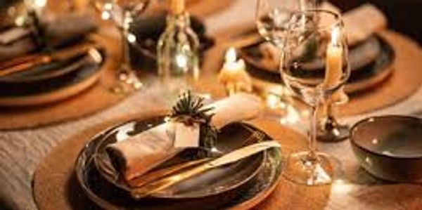 Elegant dinner table setting with candles and glassware.