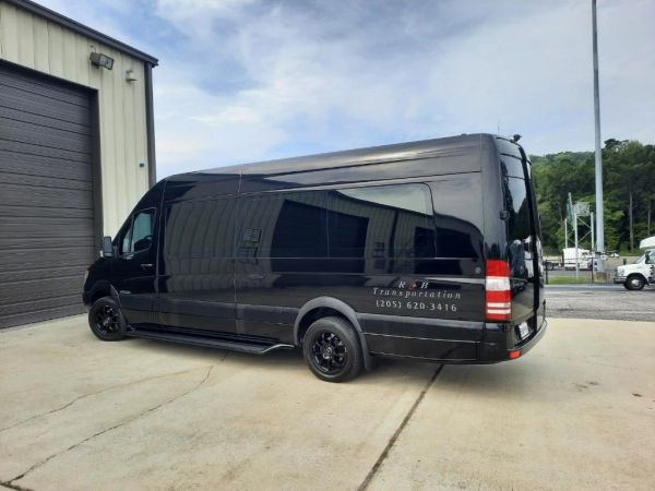 Black transport van parked outside a building.