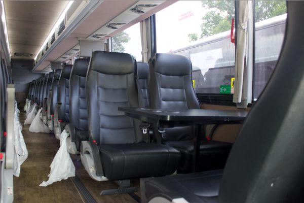 Empty seats with a table inside a bus.