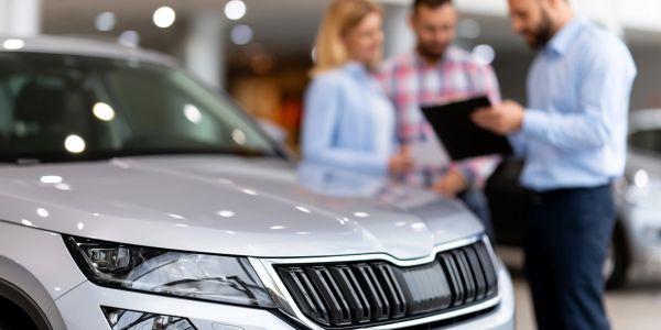 Car dealership consultation with customers and a salesperson.