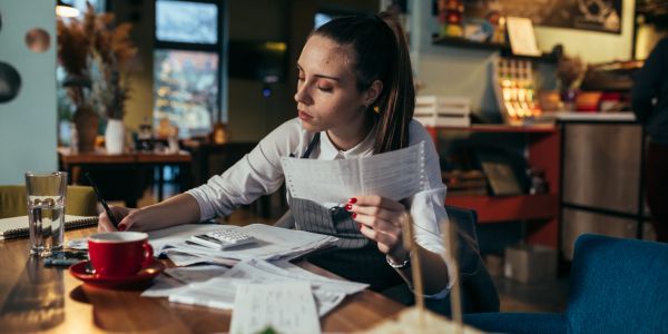Woman reviewing financial documents in a cafe.