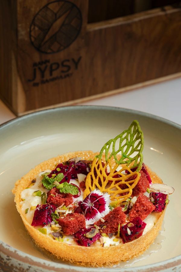 Elegant dessert tart garnished with edible flowers and colorful decorations.
