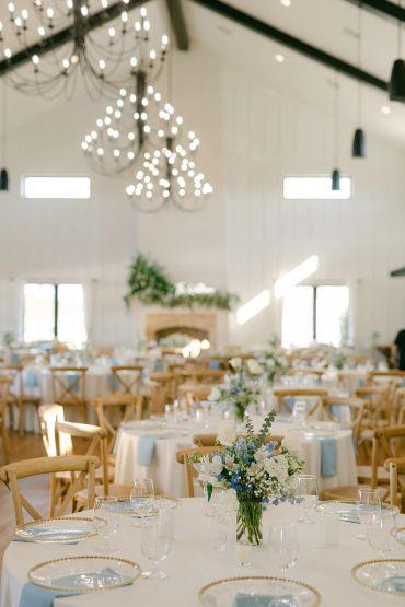 Elegant wedding reception setup with floral centerpieces and chandeliers.