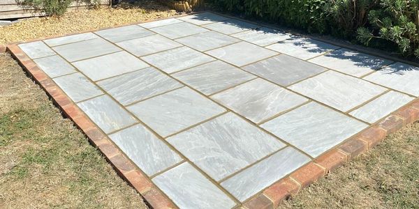 Newly installed stone patio with brick border.