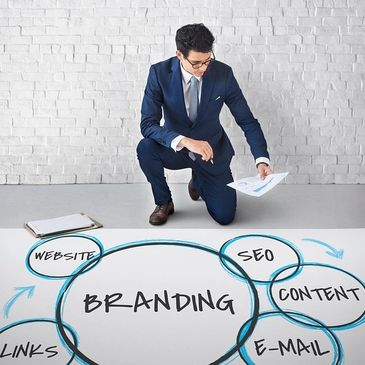 A businessman analyzing branding strategy with key elements on a large paper.