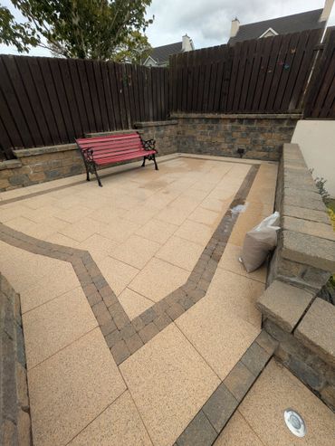 A tiled outdoor patio with a red bench and surrounding stone walls.